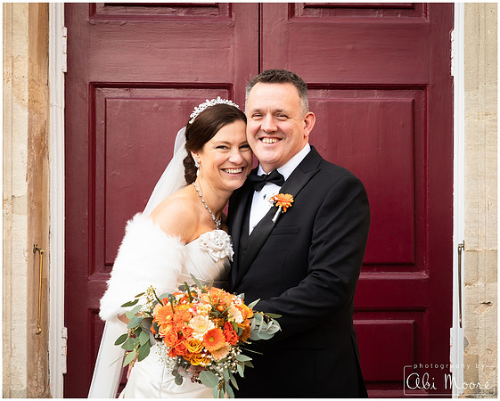 Bride & groom laugh together in front of Windsor Guildhall's red doors
