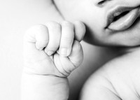 Black & white close up of newborn baby's hand and lips