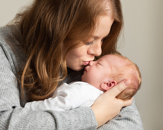 Close-up photo of mother kissing her newborn baby on its nose