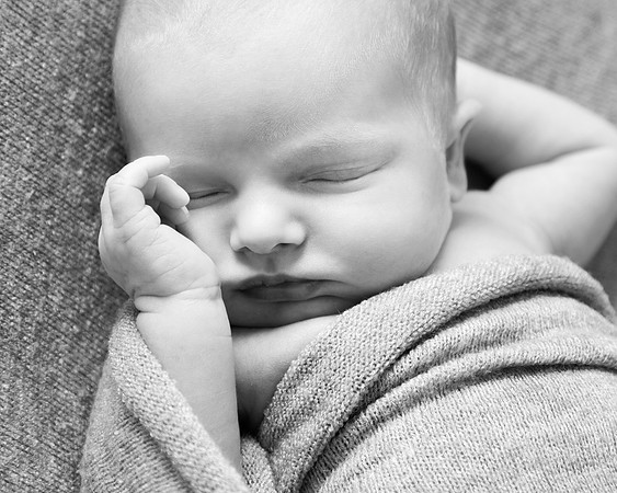 A close-up black and white baby photo of a newborn's sleeping face