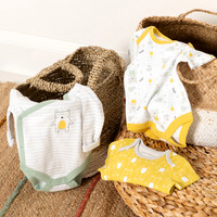 Three baby vests laid out on wicker baskets