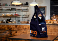 A tote bag photographed on a table in a cafe