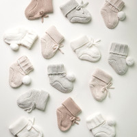 A selection of knitted booties scattered as though falling