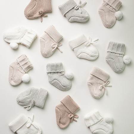 A selection of knitted booties scattered as though falling