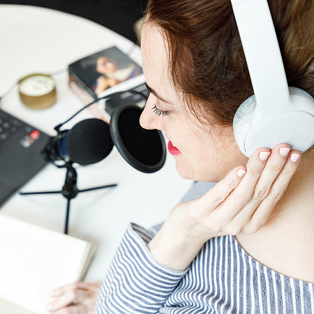 Lady recording a podcast as part of her business marketing.