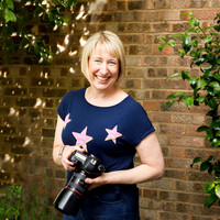 Abi Moore photographed outside smiling holding her camera