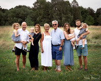 Three generations of the same family photographed together in a meadow