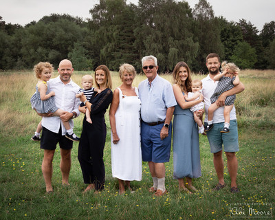 Three generations of the same family photographed together in a meadow