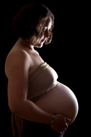Studio photo of pregnant mother with light highlighting her baby bump