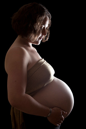 Studio photo of pregnant mother with light highlighting her baby bump