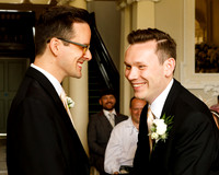 Two grooms laugh during their wedding ceremony