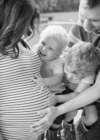 Family smile and touch mum's pregnant baby bump