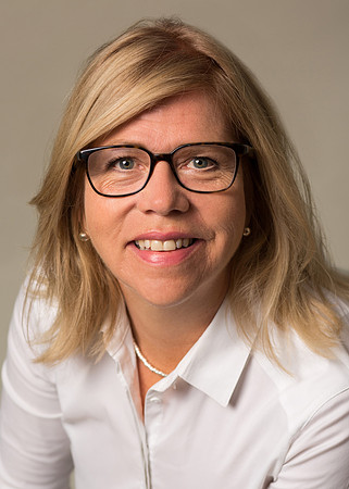 A professional studio headshot of a woman