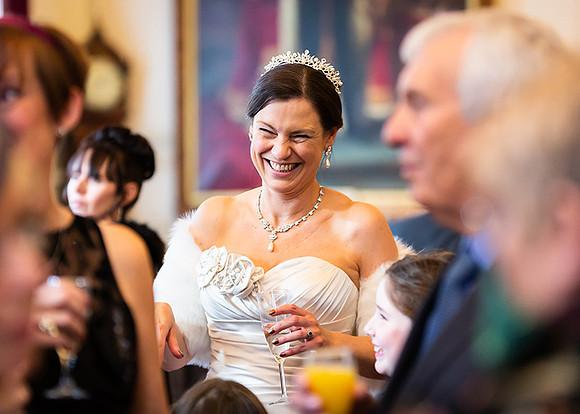 Bride captured candidly smiling during her wedding reception in Windsor Guildhall