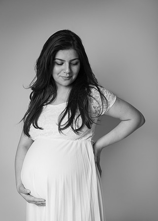 Mother cradles and looks down at her baby bump