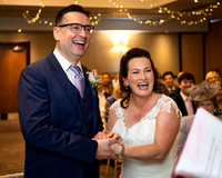 Bride and groom laugh during their winter wedding ceremony
