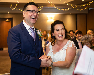Bride and groom laugh during their winter wedding ceremony