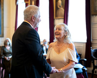 An older wedding couple smile at each other during their Windsor Guildhall wedding ceremony