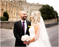 A bride and groom smile at each other outside Windsor Castle