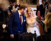 A groom wispers to his smiling bride during a wedding ceremony at Windsor's Guildhall