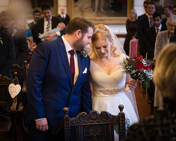 A groom wispers to his smiling bride during a wedding ceremony at Windsor's Guildhall