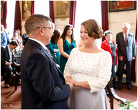Bride & groom smile at each other as they hold hands and say their wedding vows at Windsor Guildhall