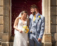 Bride and groom laugh as they are showered with confetti outside the Windsor Guildhall