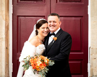 A bride and groom smile naturally outside the doors of Windsor Guildhall