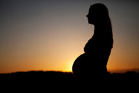 Silhouette of pregnant mother at sunset