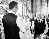 Father-of-the-bride, bride and groom all laugh as he gives her away