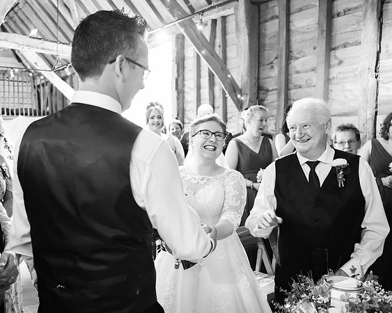 Father-of-the-bride, bride and groom all laugh as he gives her away