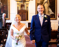 A wedding couple walk out of their Windsor Guildhall ceremony with huge smiles on their faces