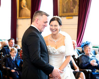 A bride and groom laugh together during their wedding ceremony