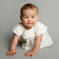 Baby girl crawling towards the camera in a photo studio