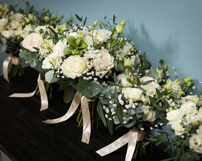 Wedding bouquets of ivory roses lined up in a row